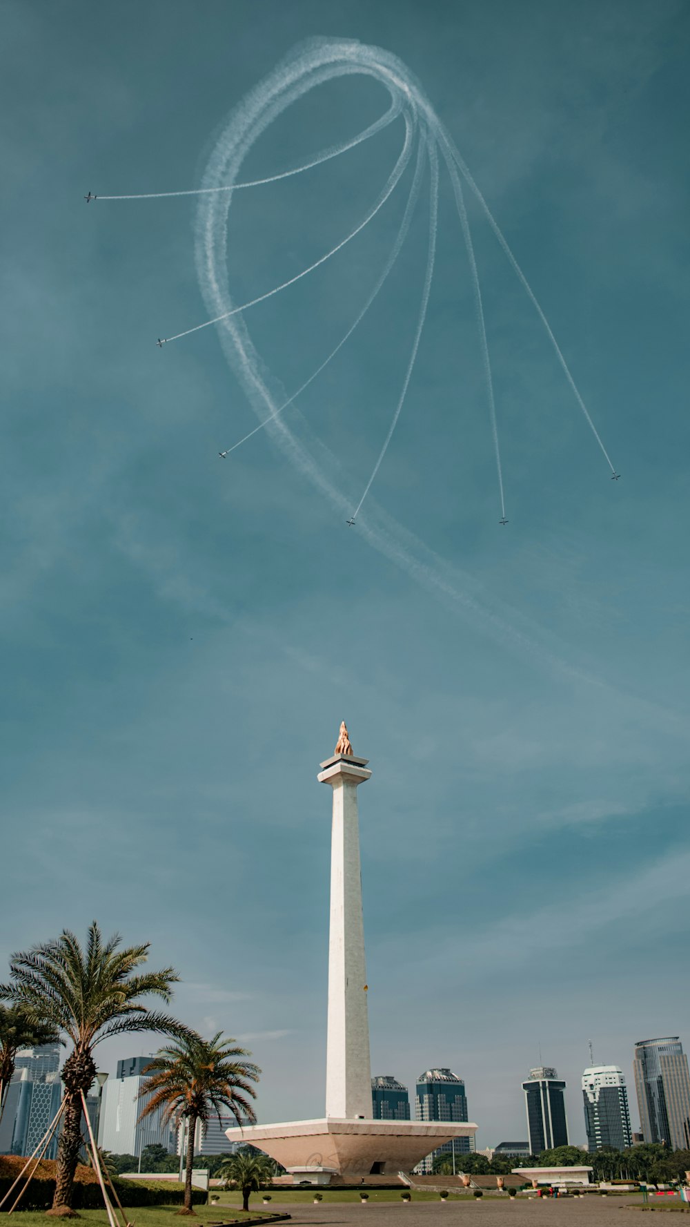 a contrail in the sky over a monument