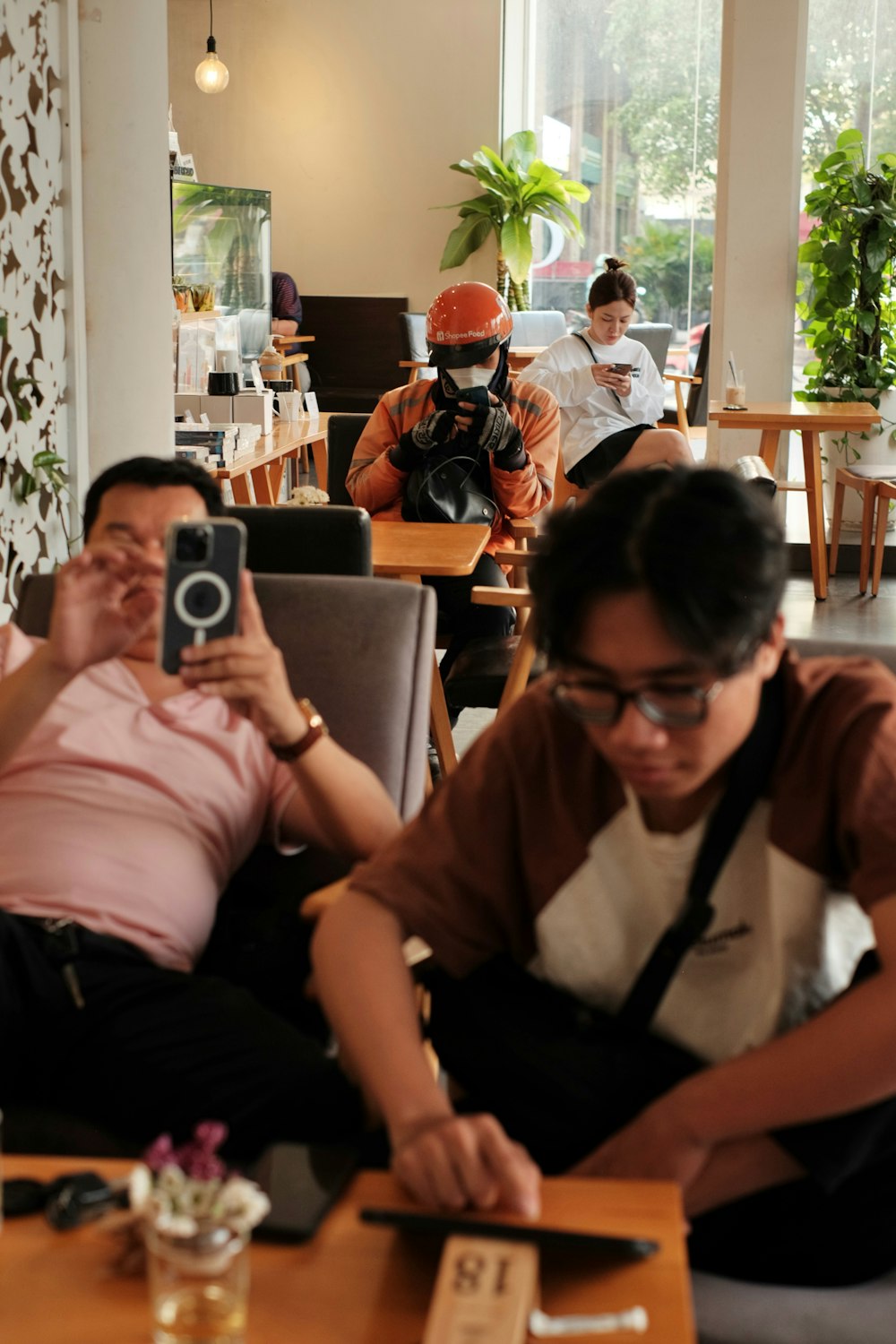 a woman taking a picture of a man in a restaurant