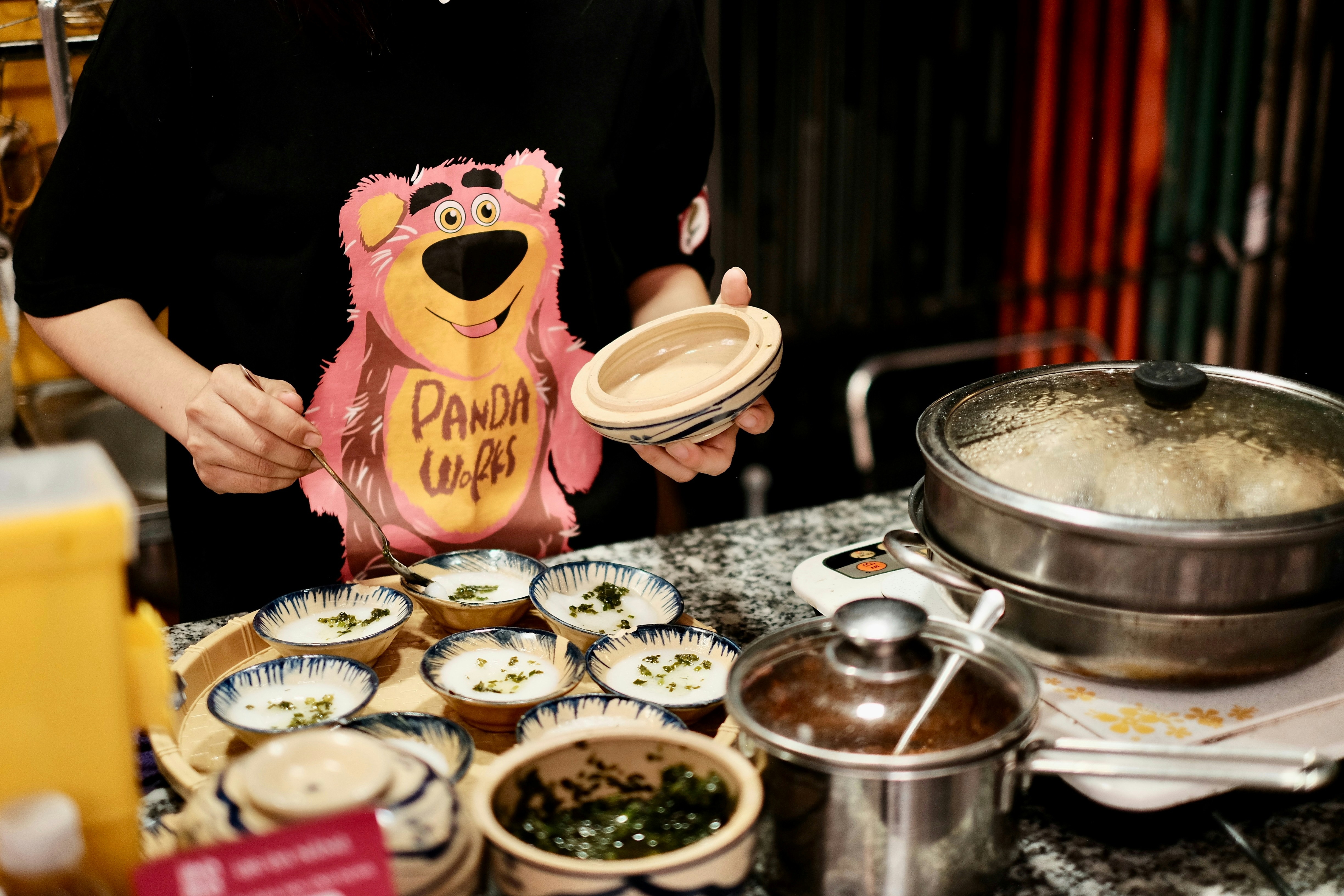 a woman is holding a pink bear shaped cookie