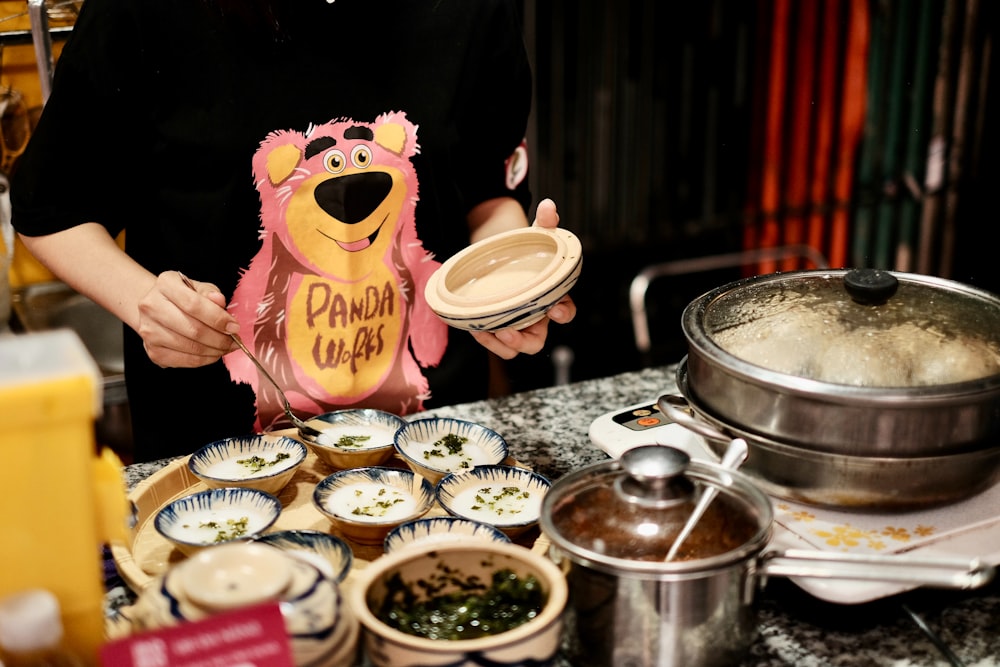 a woman is holding a pink bear shaped cookie