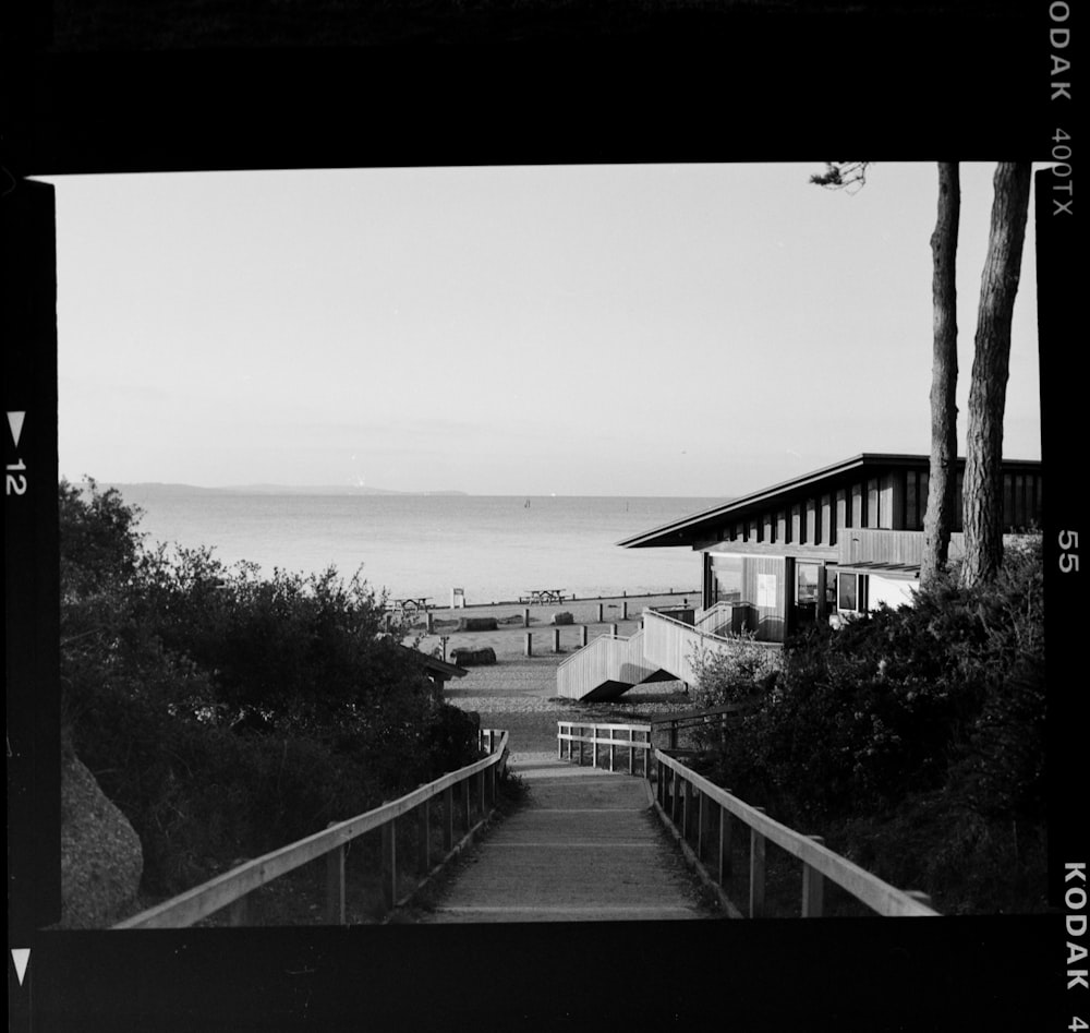 a black and white photo of stairs leading to the beach