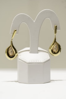 a pair of gold and diamond earrings