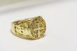 a close up of a gold ring on a white surface