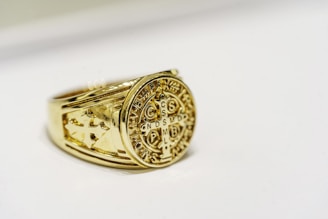 a close up of a gold ring on a white surface