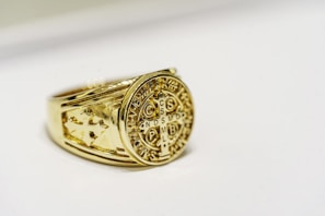 a close up of a gold ring on a white surface