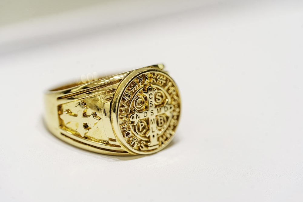 a close up of a gold ring on a white surface