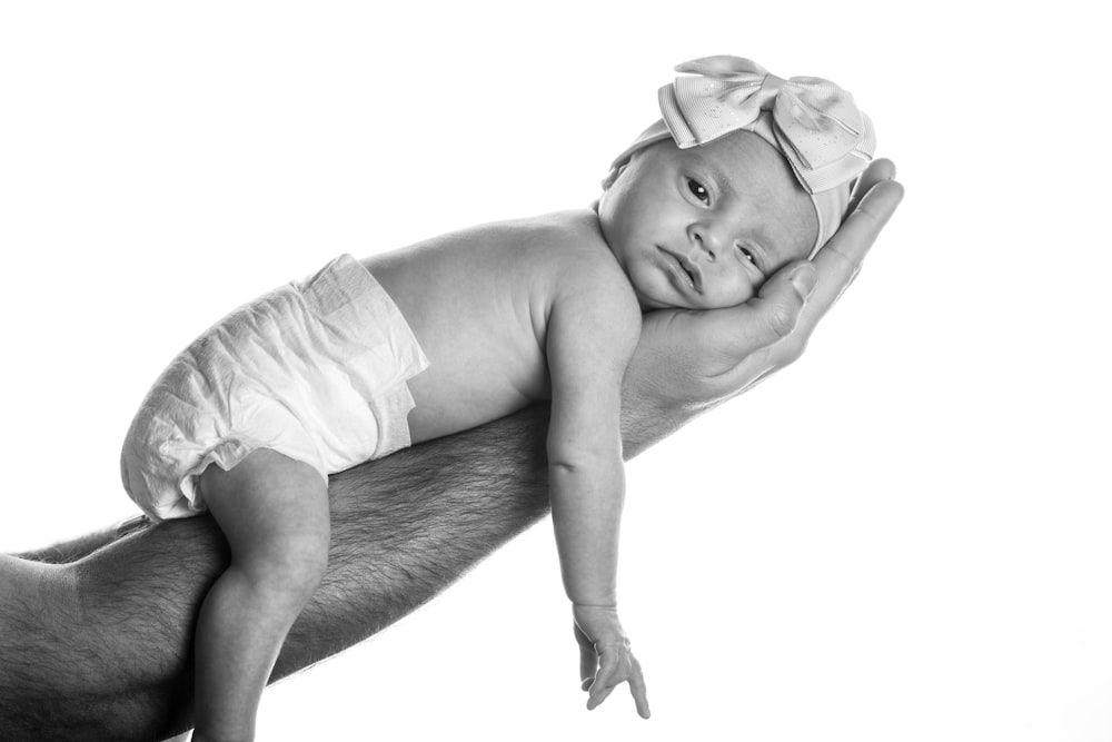 a black and white photo of a man holding a baby