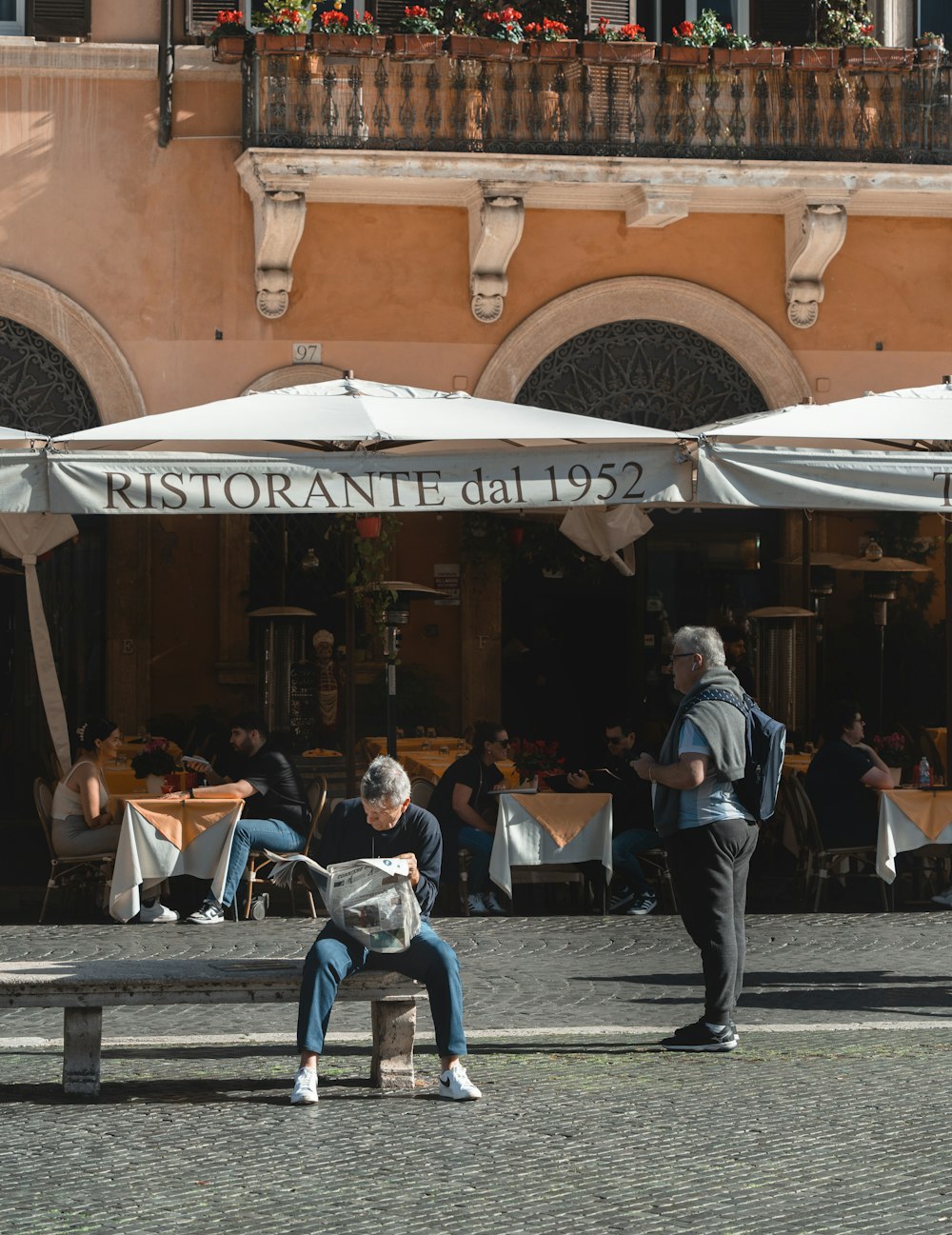 a man sitting on a bench in front of a restaurant