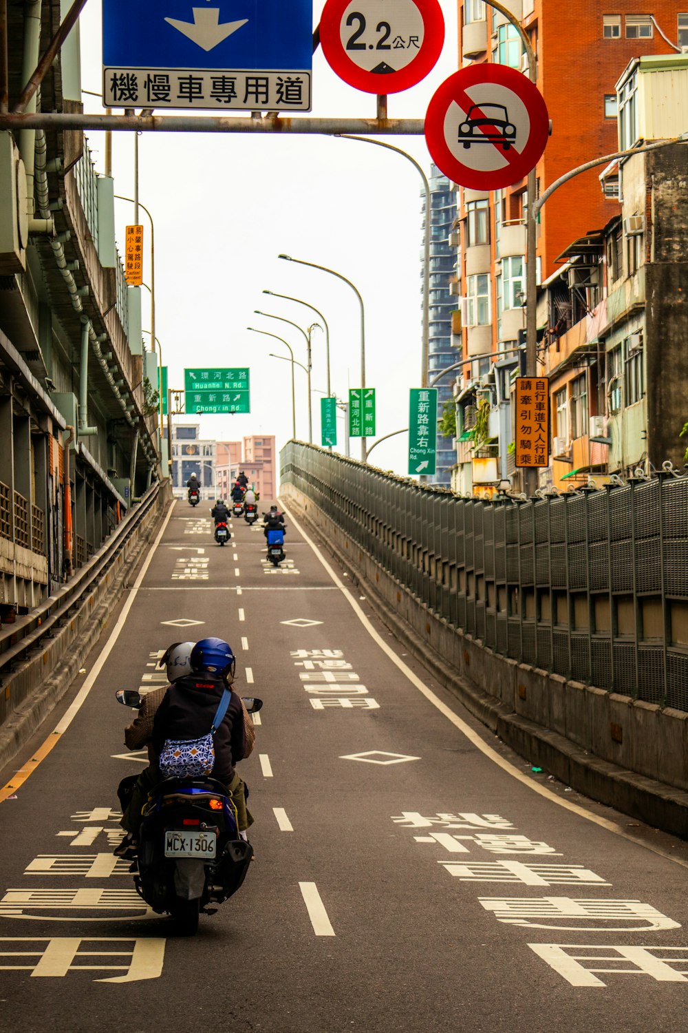 a group of people riding motorcycles down a street