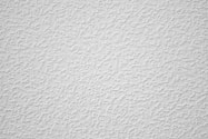 a white textured wall with a small amount of paint on it
