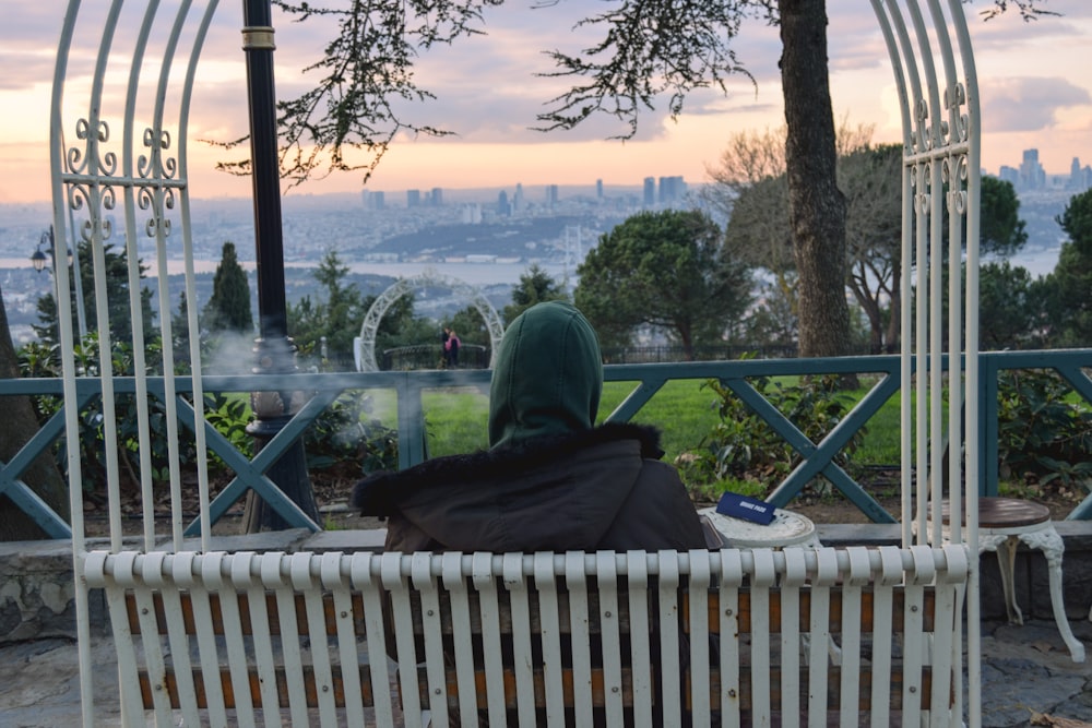 a person sitting on a bench in a park