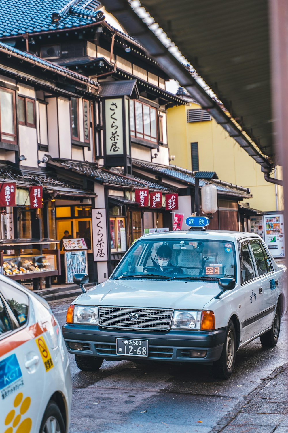 ein Taxi, das eine Straße neben hohen Gebäuden entlangfährt