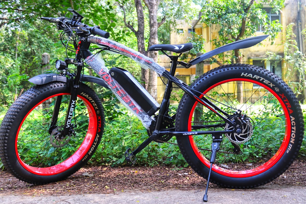 a bicycle with red rims parked on the side of a road