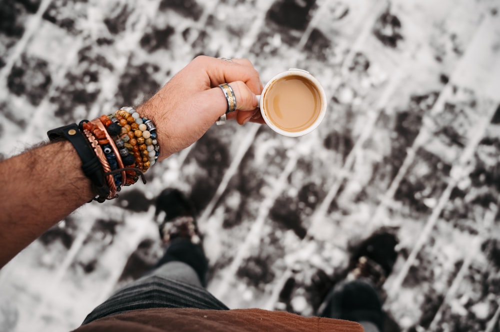 a person holding a cup of coffee in their hand