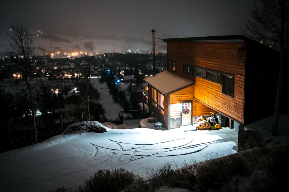 a house is lit up at night in the snow