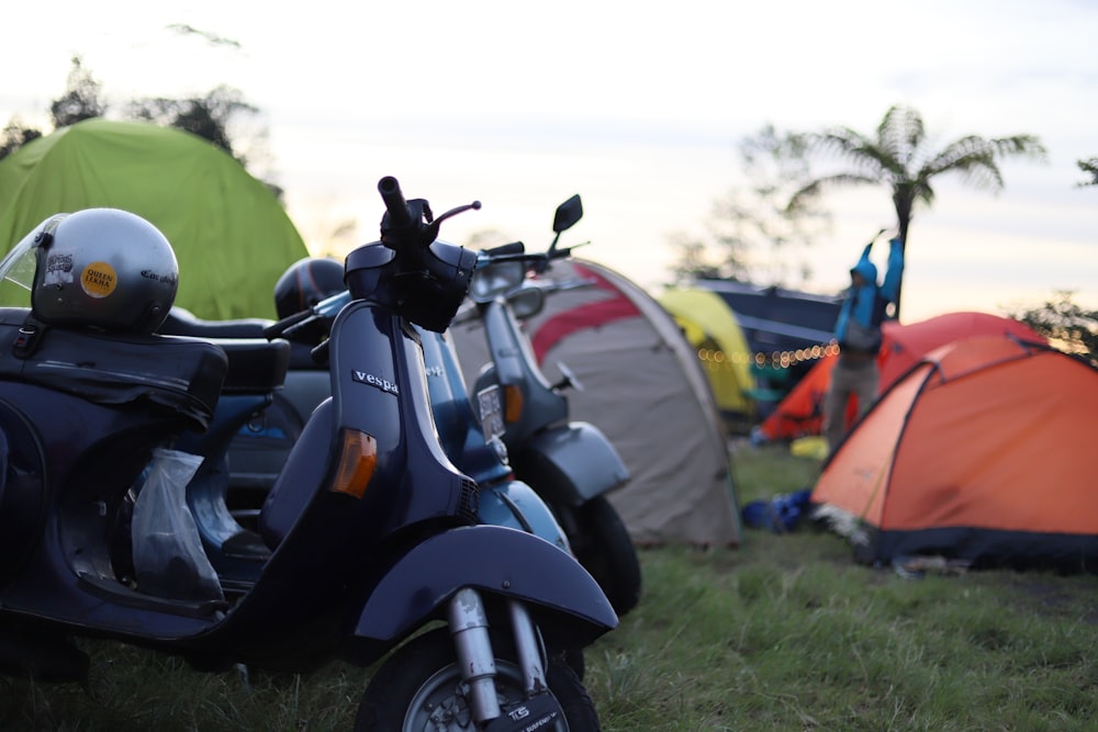 a scooter parked next to a tent in the grass
