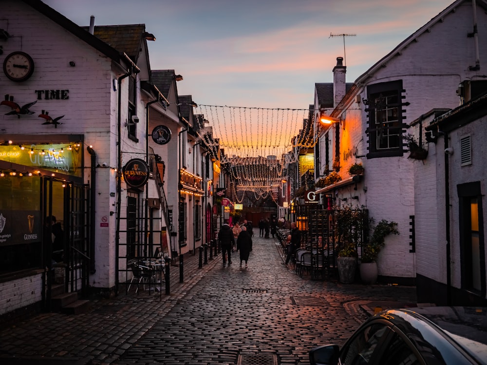 a cobblestone street with people walking down it