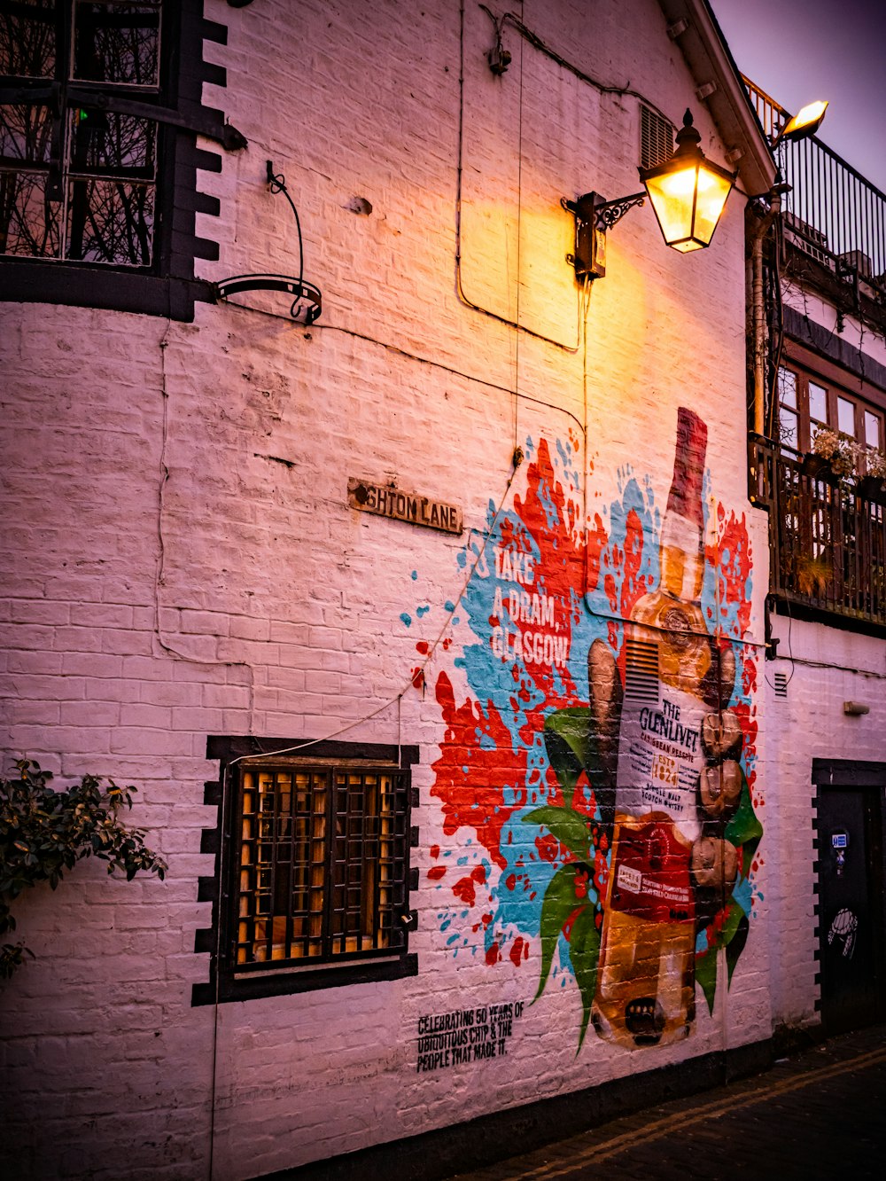 a white brick building with a painted mural on it