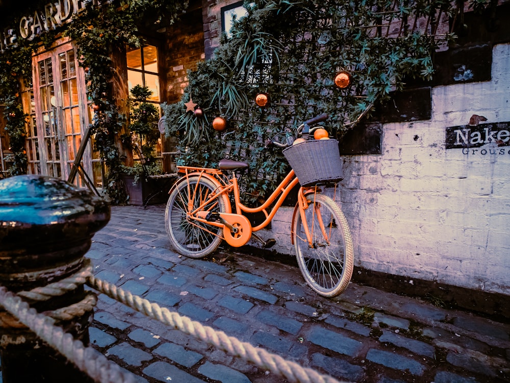 an orange bike parked next to a building