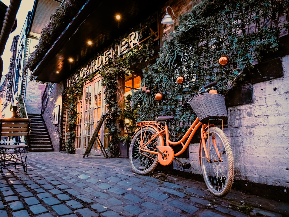 an orange bike parked next to a building