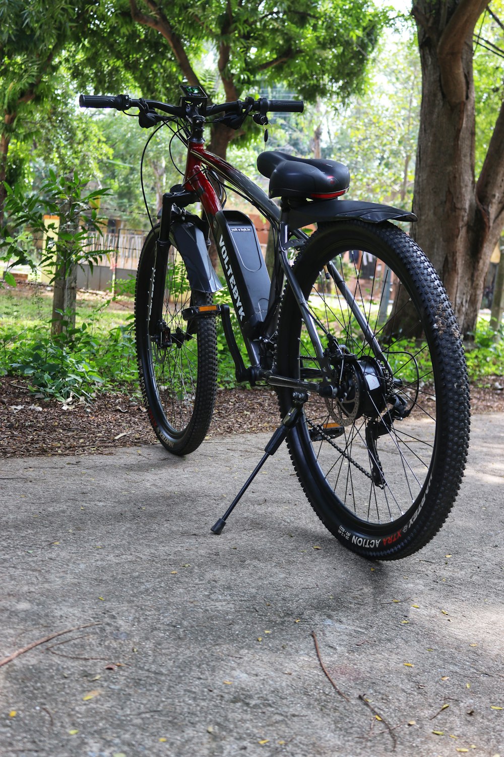 uma bicicleta estacionada em um parque ao lado de uma árvore