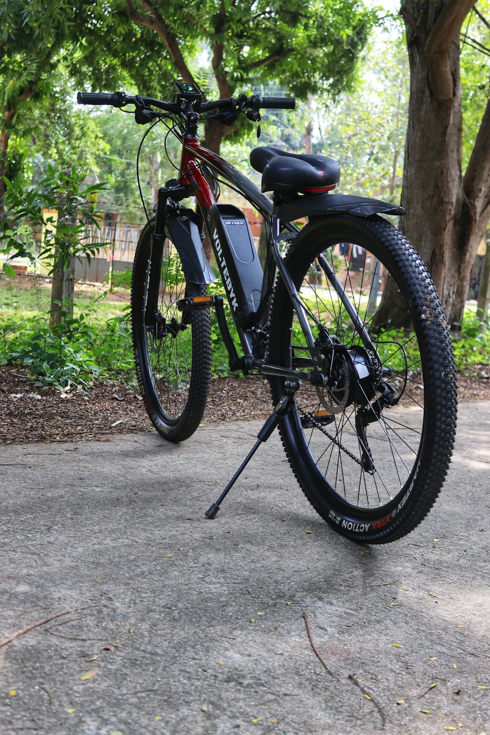 a bicycle parked in a park next to a tree