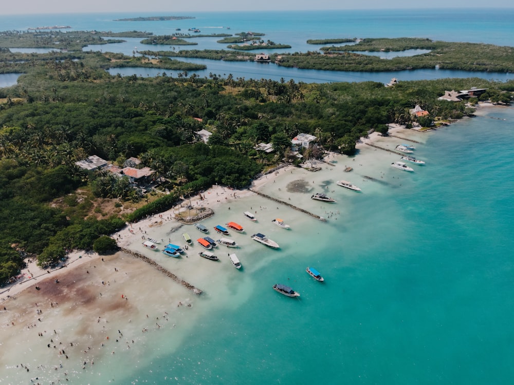 an aerial view of a beach with boats in the water