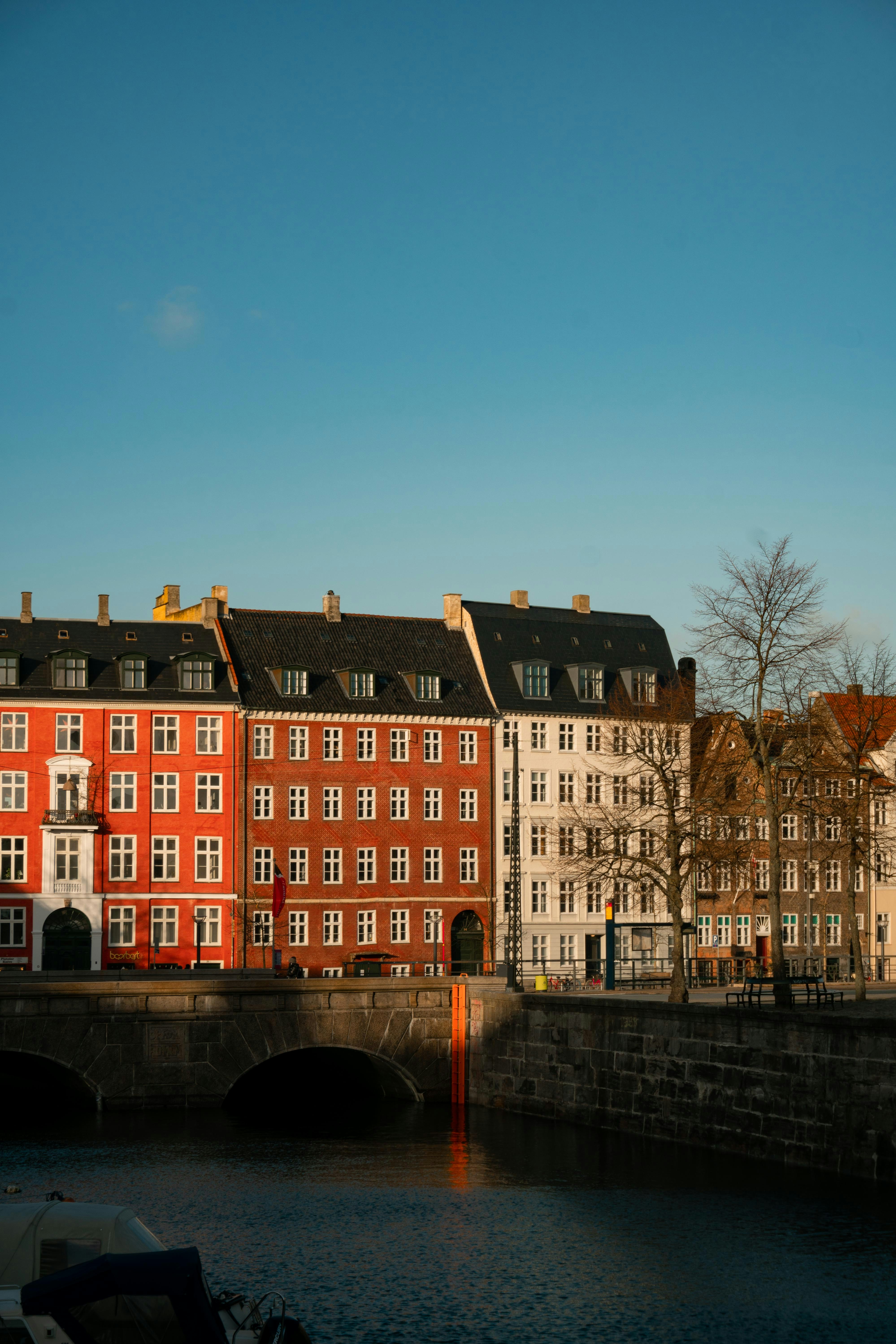 Colorful historic buildings along a canal with a stone bridge in Copenhagen