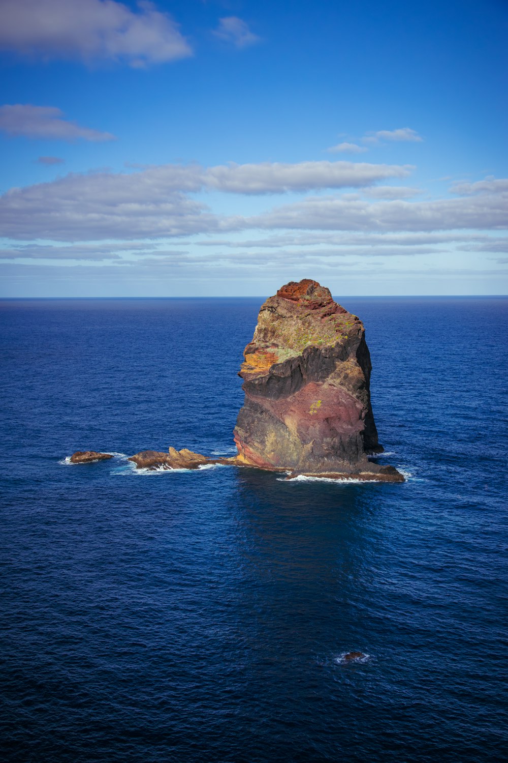 a large rock sticking out of the middle of the ocean