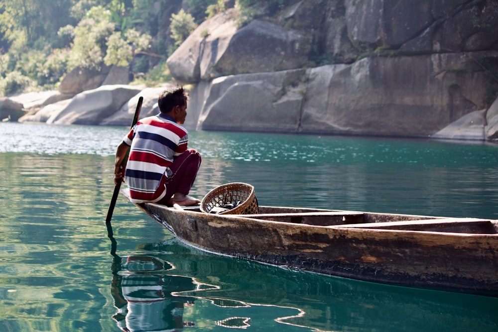 a man sitting in a boat on the water
