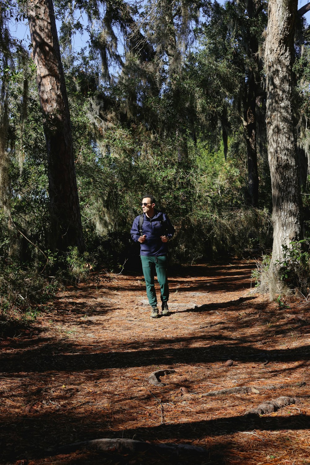 a man running down a dirt road in the woods