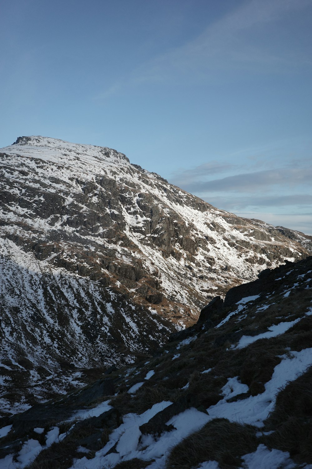 a mountain covered in snow with a sky background