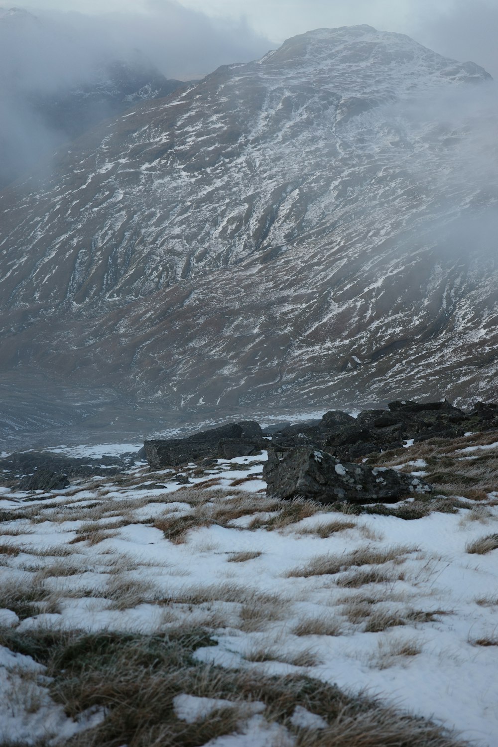 a snow covered field with a mountain in the background