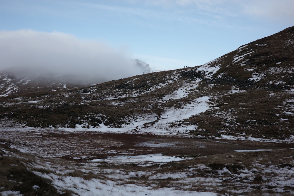 a mountain covered in snow and clouds on a cloudy day