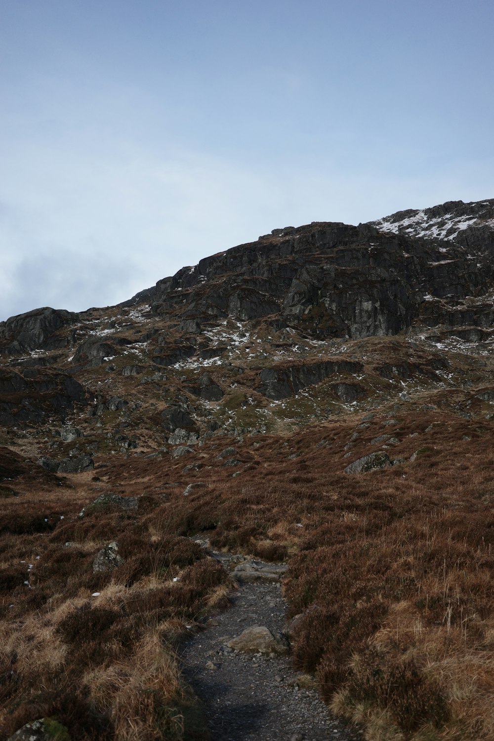 a rocky mountain with a trail leading to it