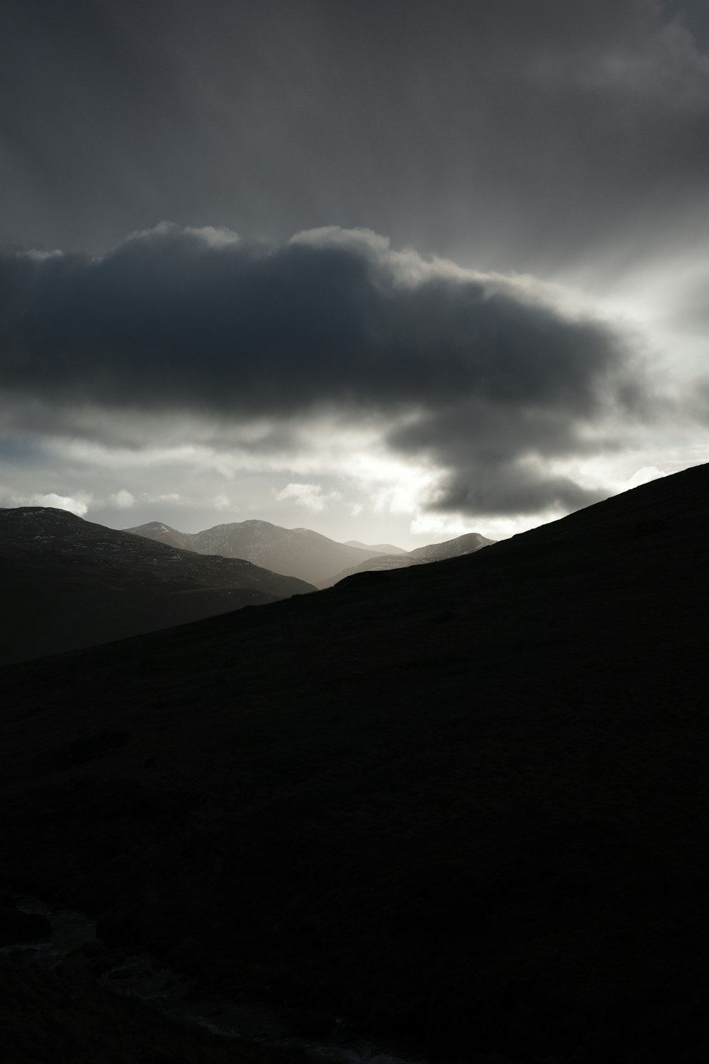 a black and white photo of a dark mountain