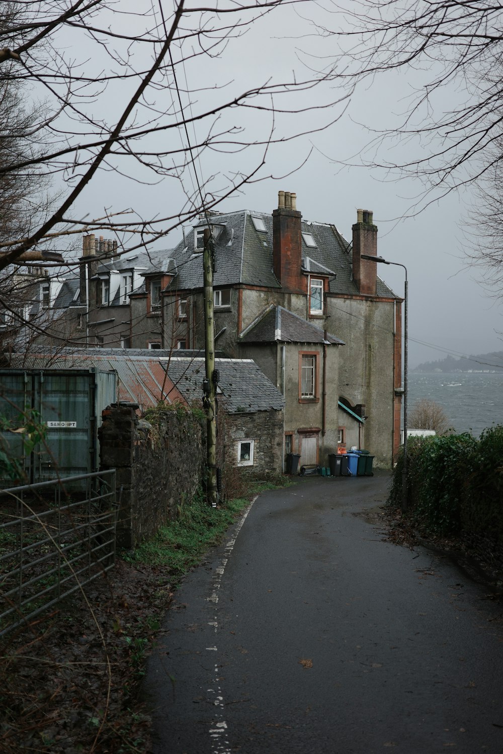 a street with a building on one side and a fence on the other side