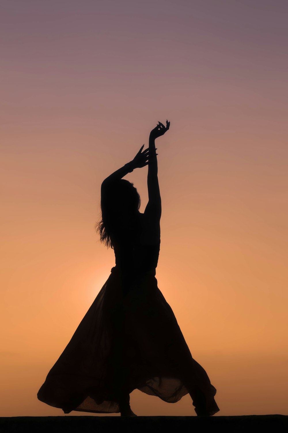 a silhouette of a woman in a long dress