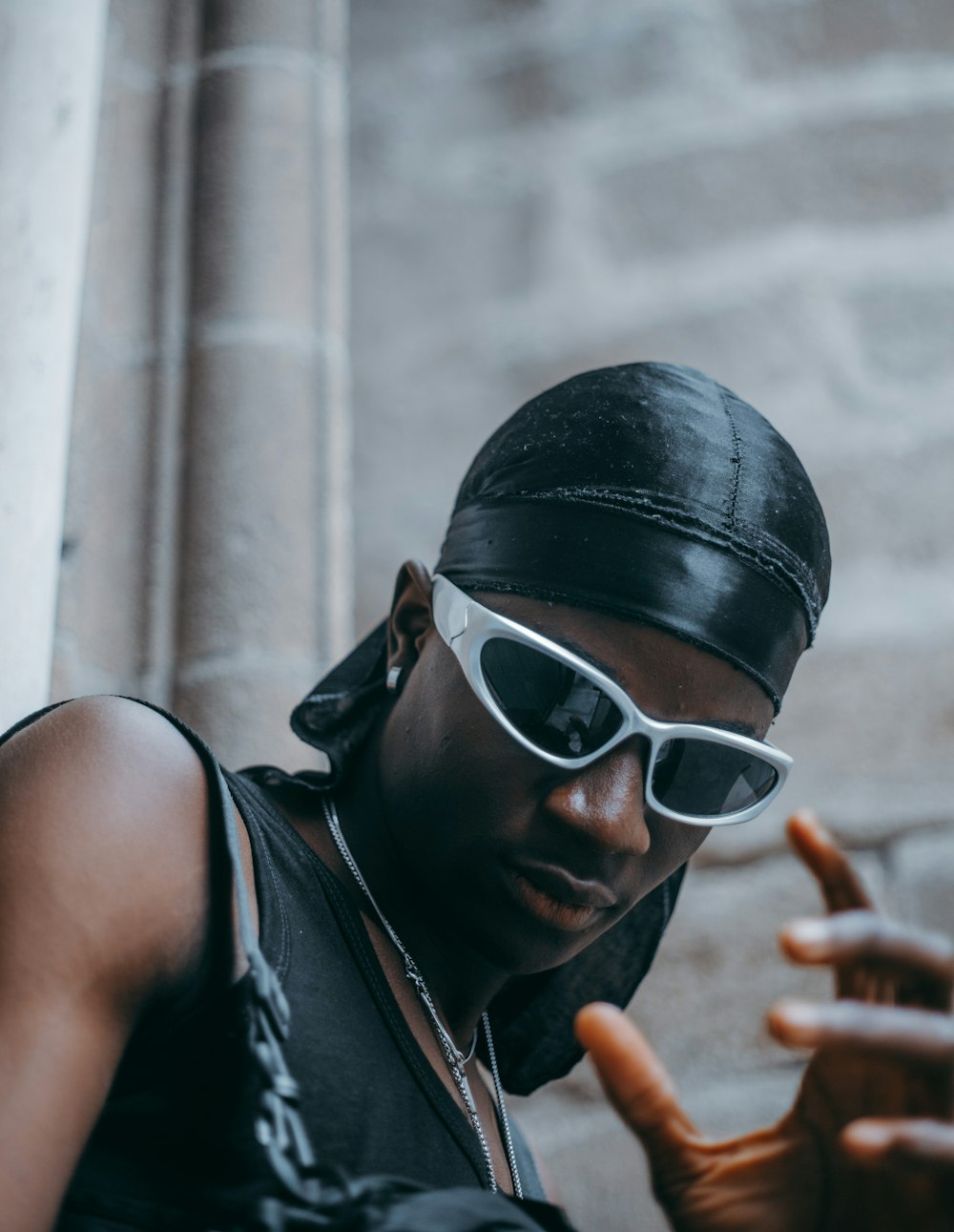 a man wearing sunglasses and a bandana smoking a cigarette