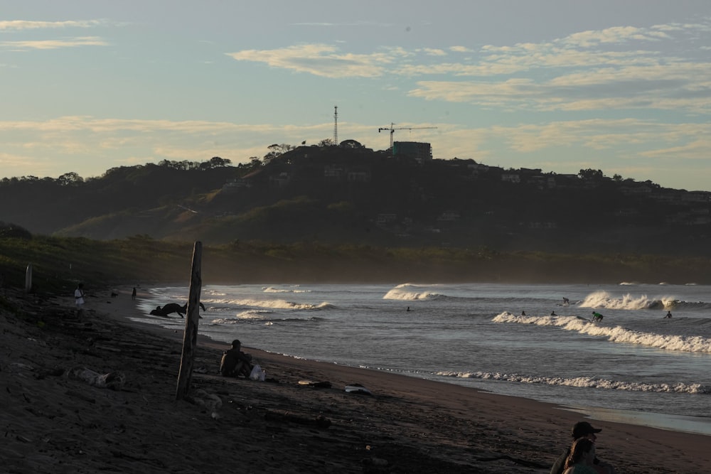 a person sitting on a beach next to the ocean