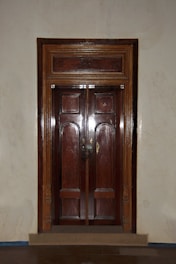 a wooden door in a room with white walls