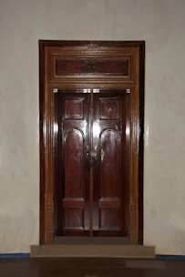 a wooden door in a room with white walls