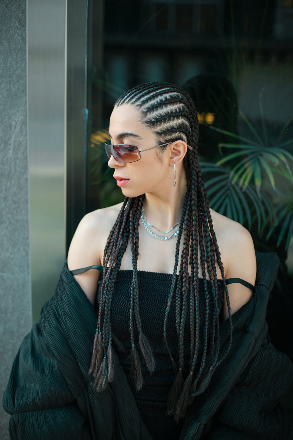 a woman with long dreadlocks wearing a black dress