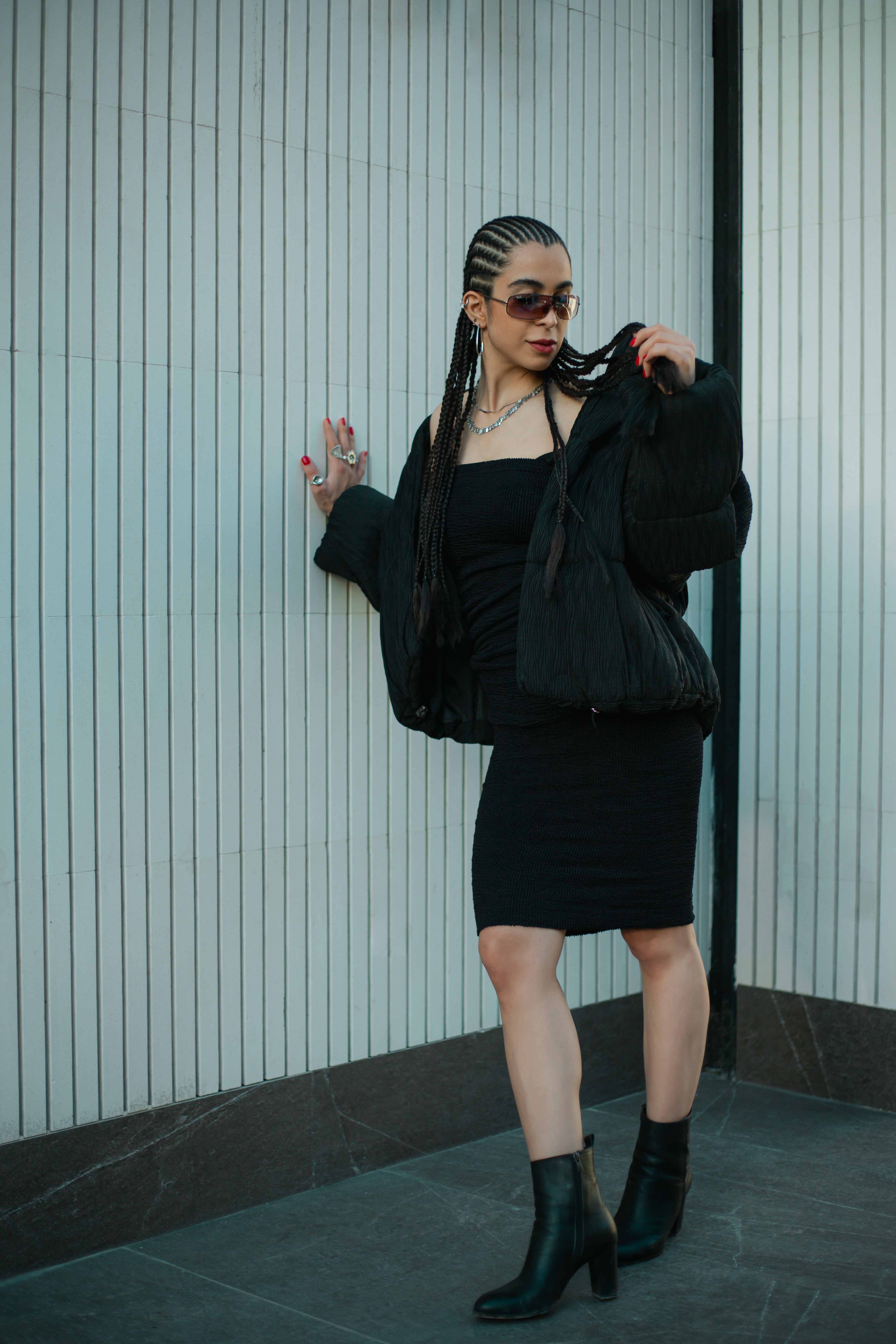 a woman wearing a black dress and black boots