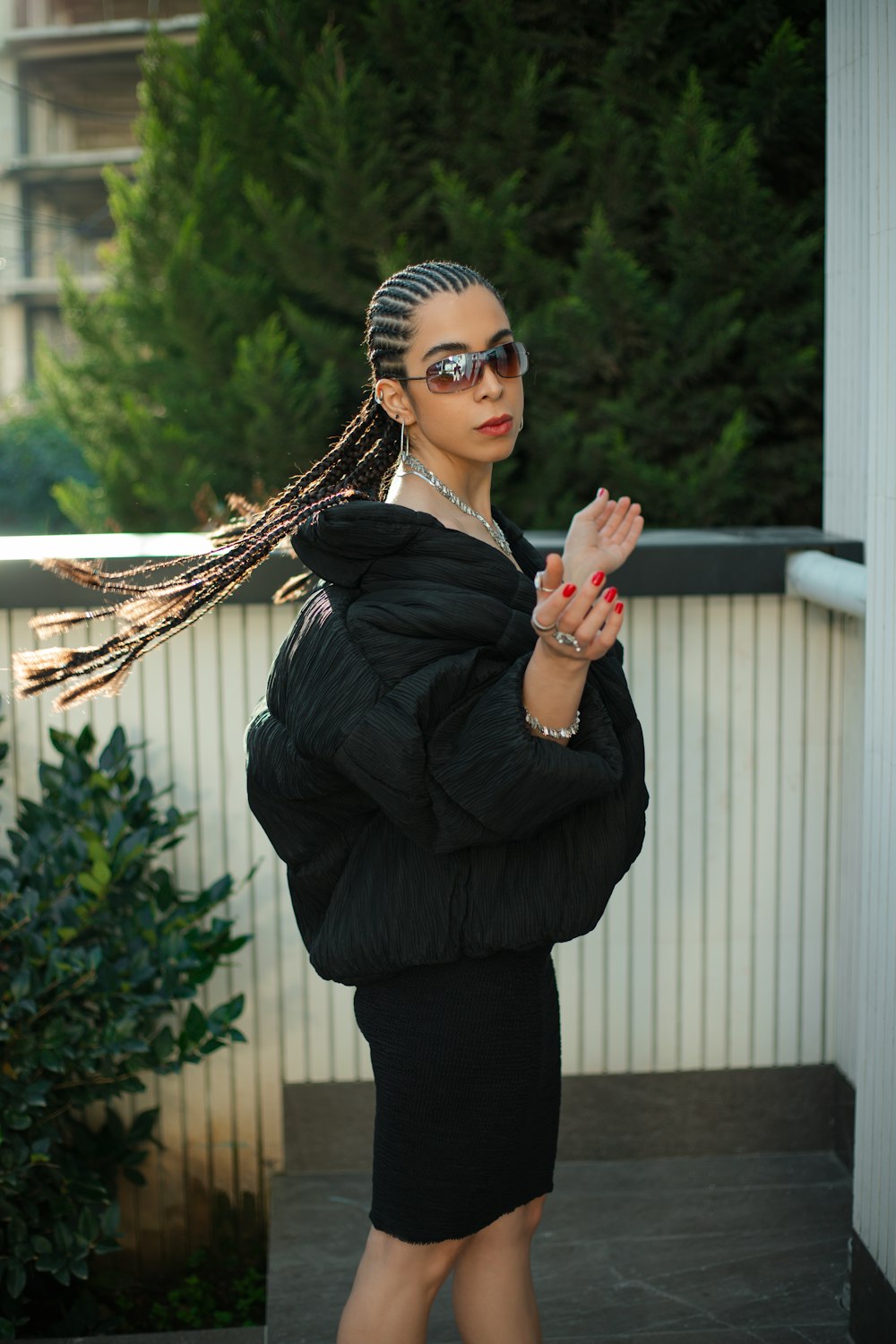 a woman with dreadlocks standing on a porch