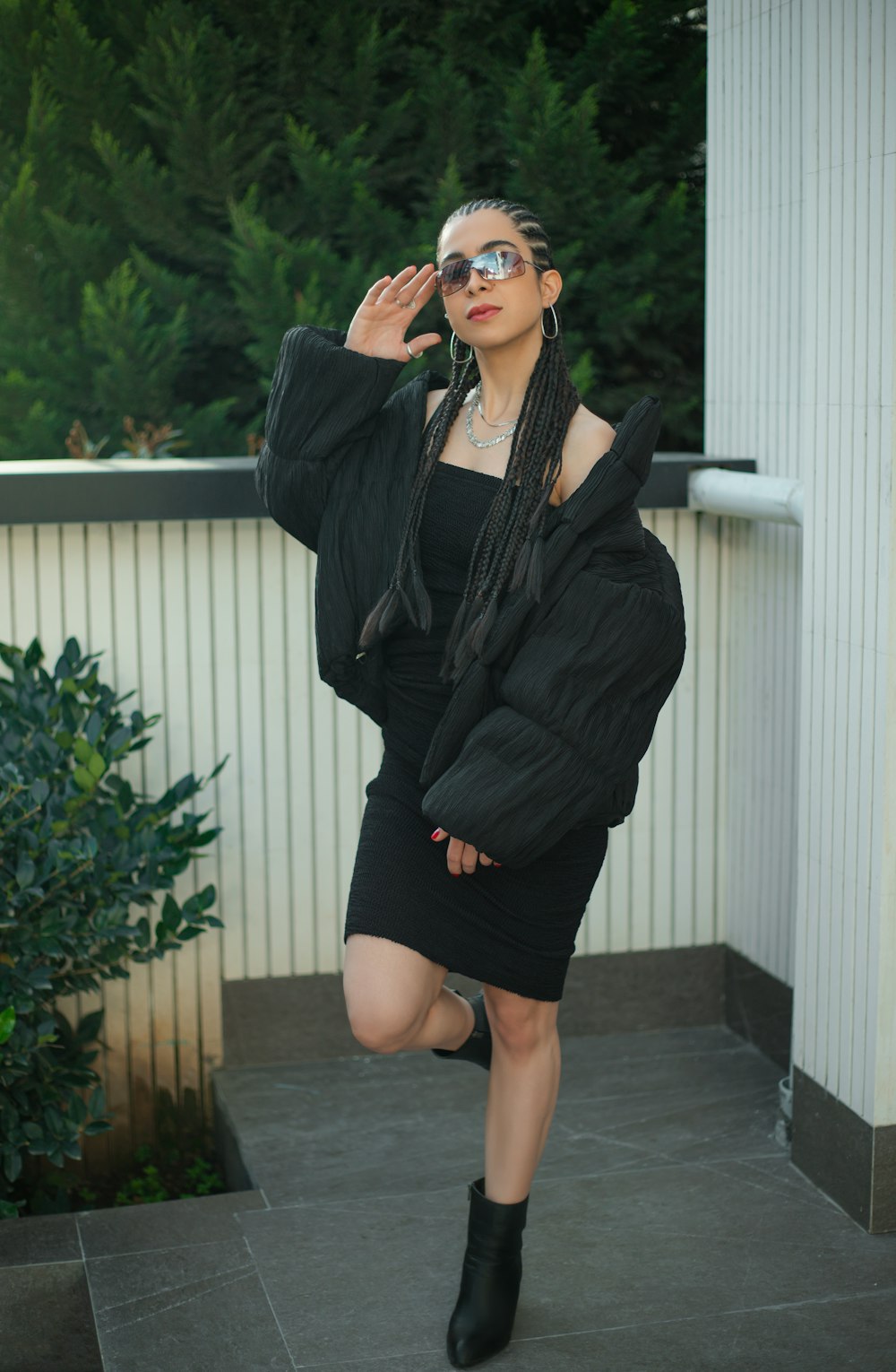 a woman in a black dress and jacket posing for a picture