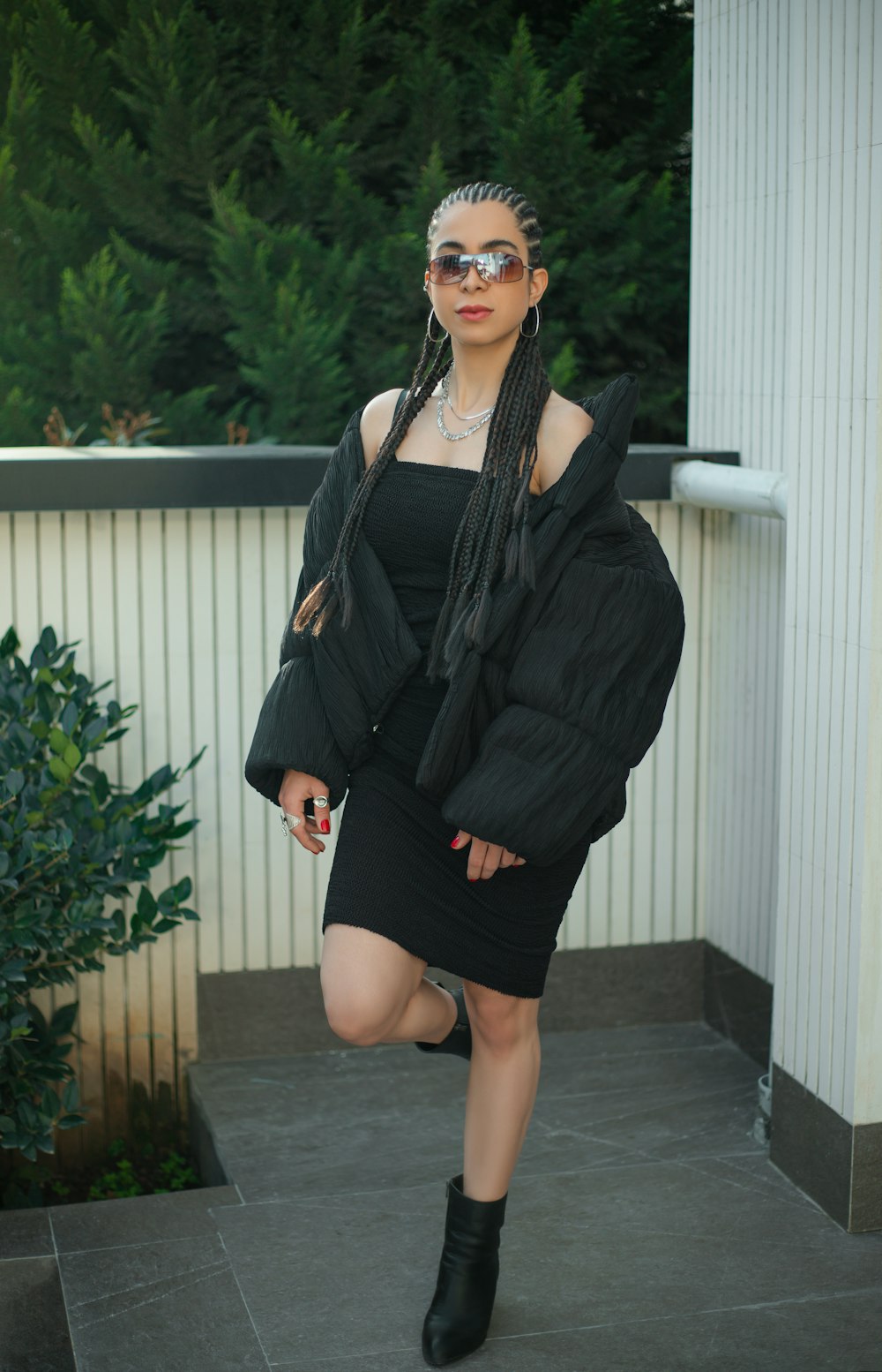 Eine Frau in schwarzem Kleid und Jacke posiert für ein Foto