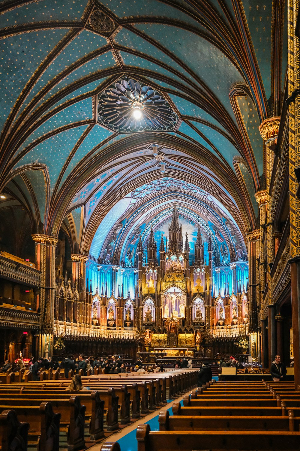 une grande cathédrale avec un plafond bleu rempli de gens