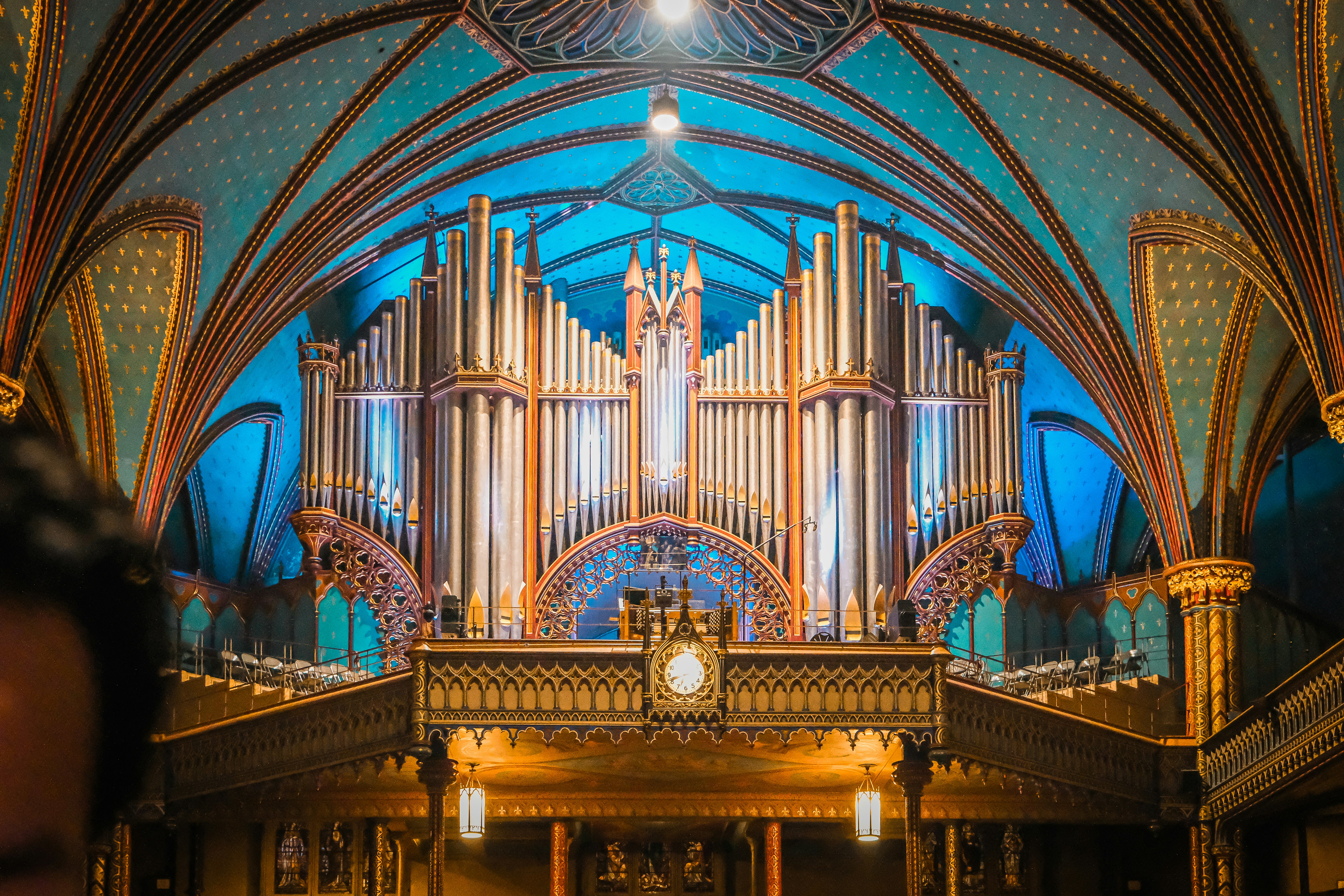 a large pipe organ in a church with a clock
