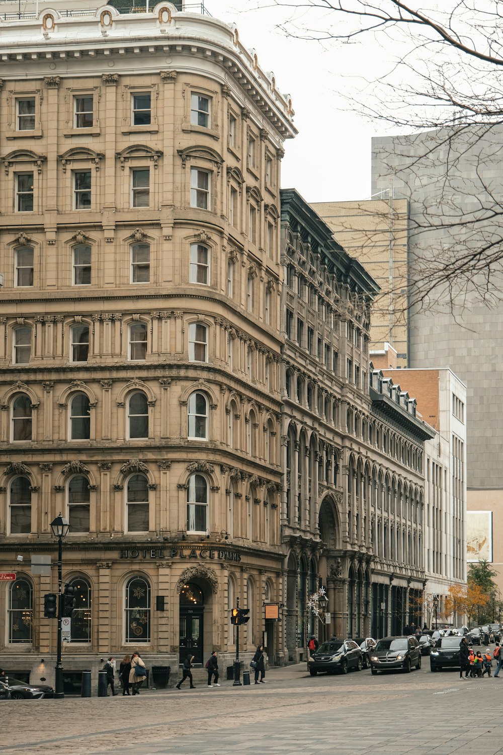 a group of people walking down a street next to tall buildings